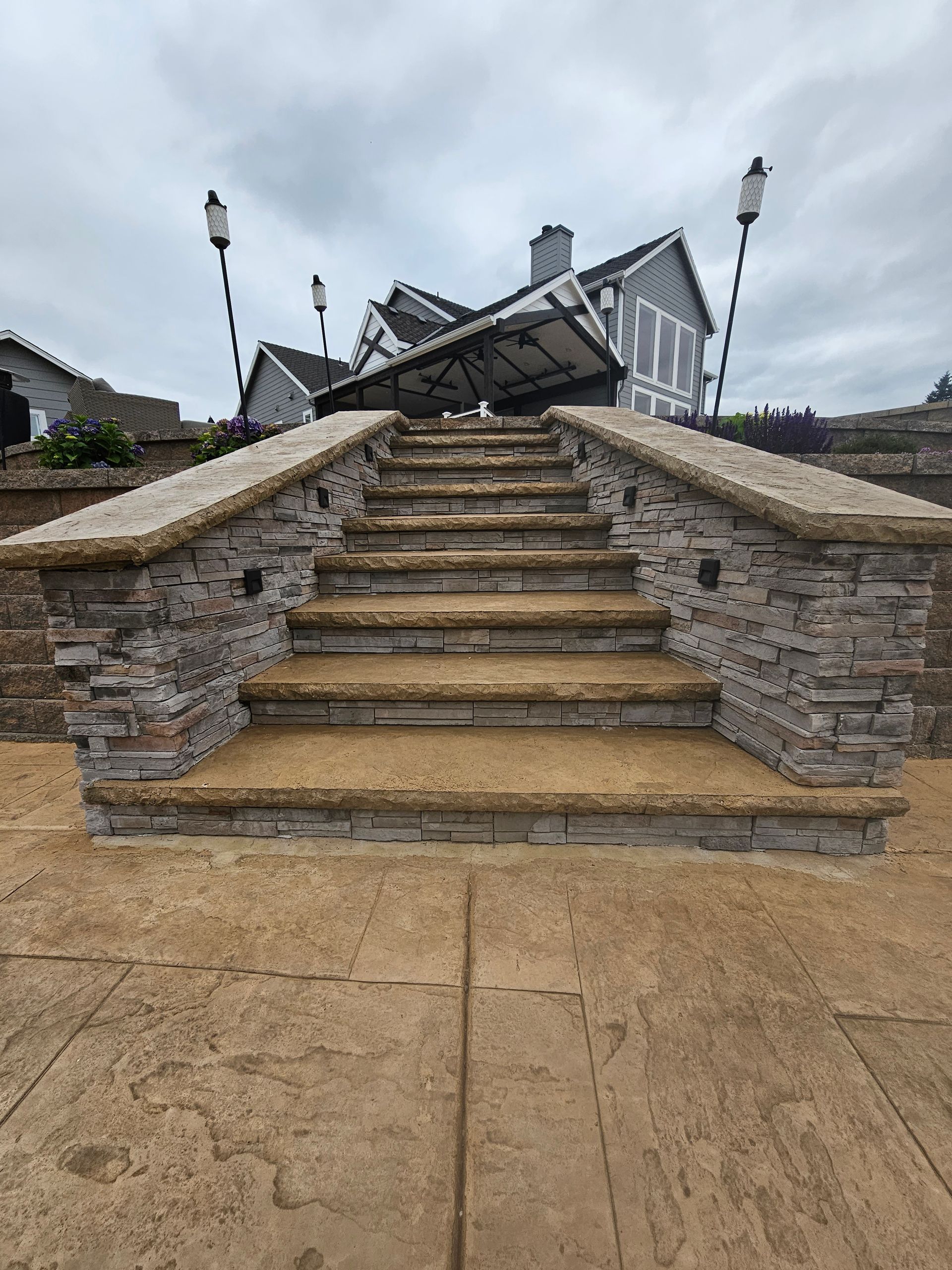 Stone staircase leading up to a building with lampposts on a cloudy day