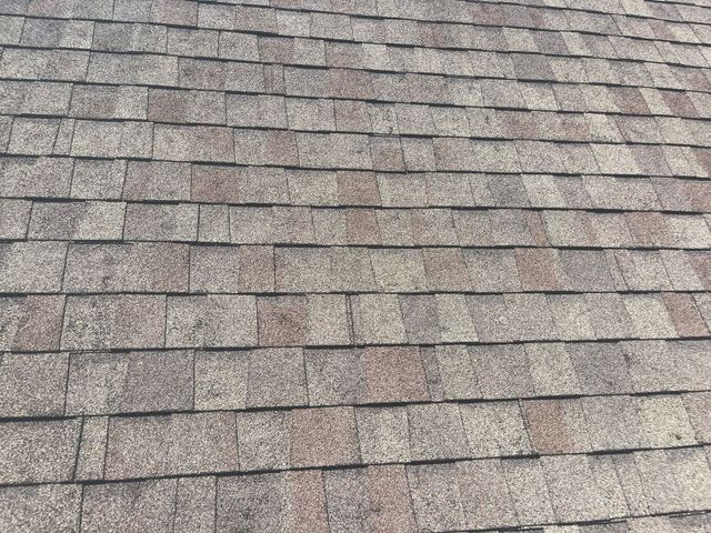 Close-up of a gray-brown asphalt shingle roof surface