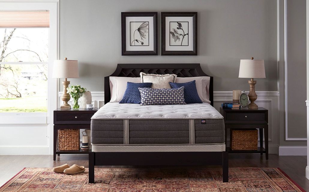 Modern bedroom with dark wood bed, blue bedding, nightstands, and framed art above the headboard