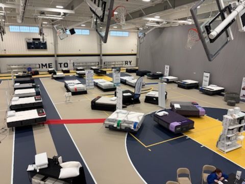 Indoor robotics competition on a basketball court with small robots on marked lanes and mats