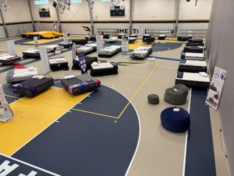 Indoor obstacle course with remote-controlled cars, bean bags, and floor markers in a gymnasium