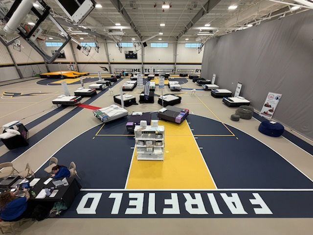 Indoor FAI aircraft exhibition with small planes on display beneath a high hangar ceiling