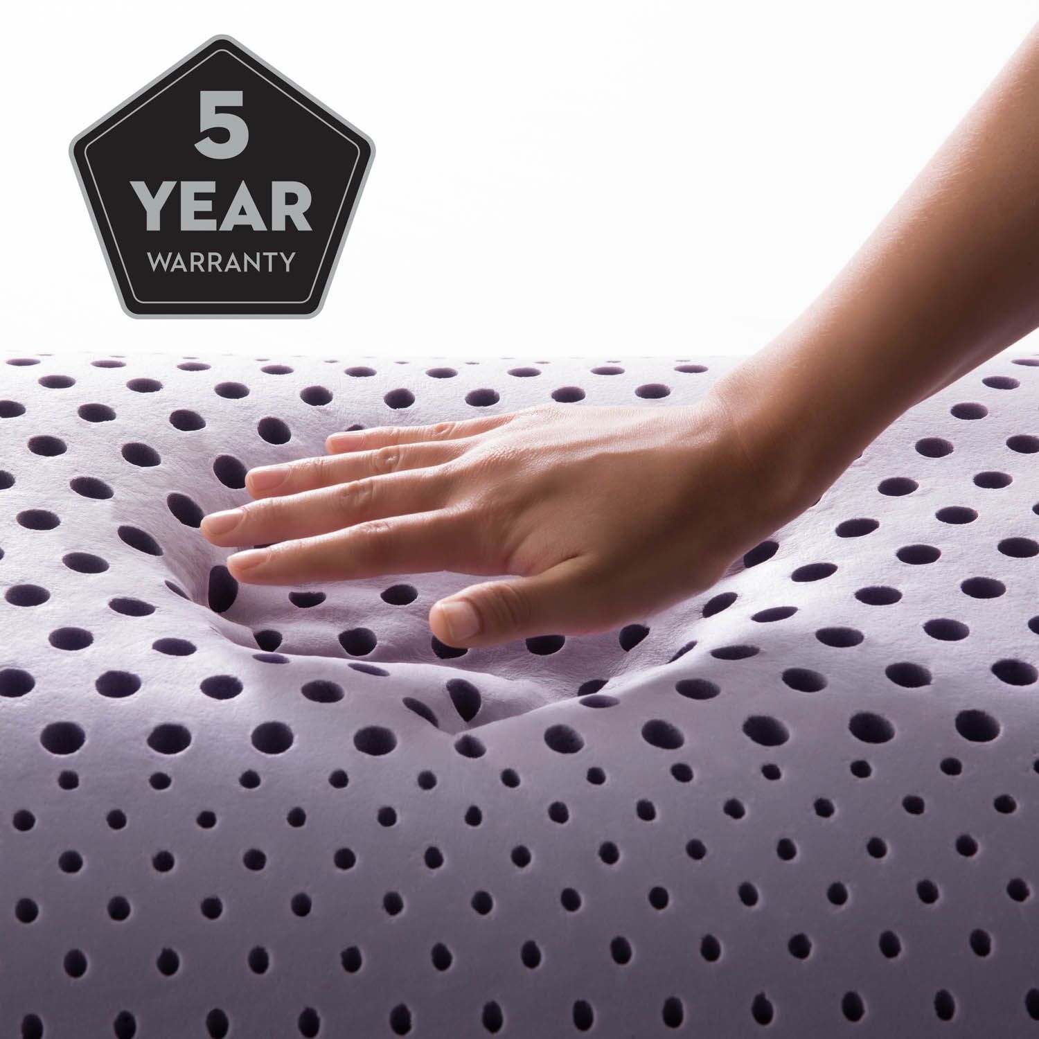 Hand pressing a white perforated mattress with a 5-year warranty badge.