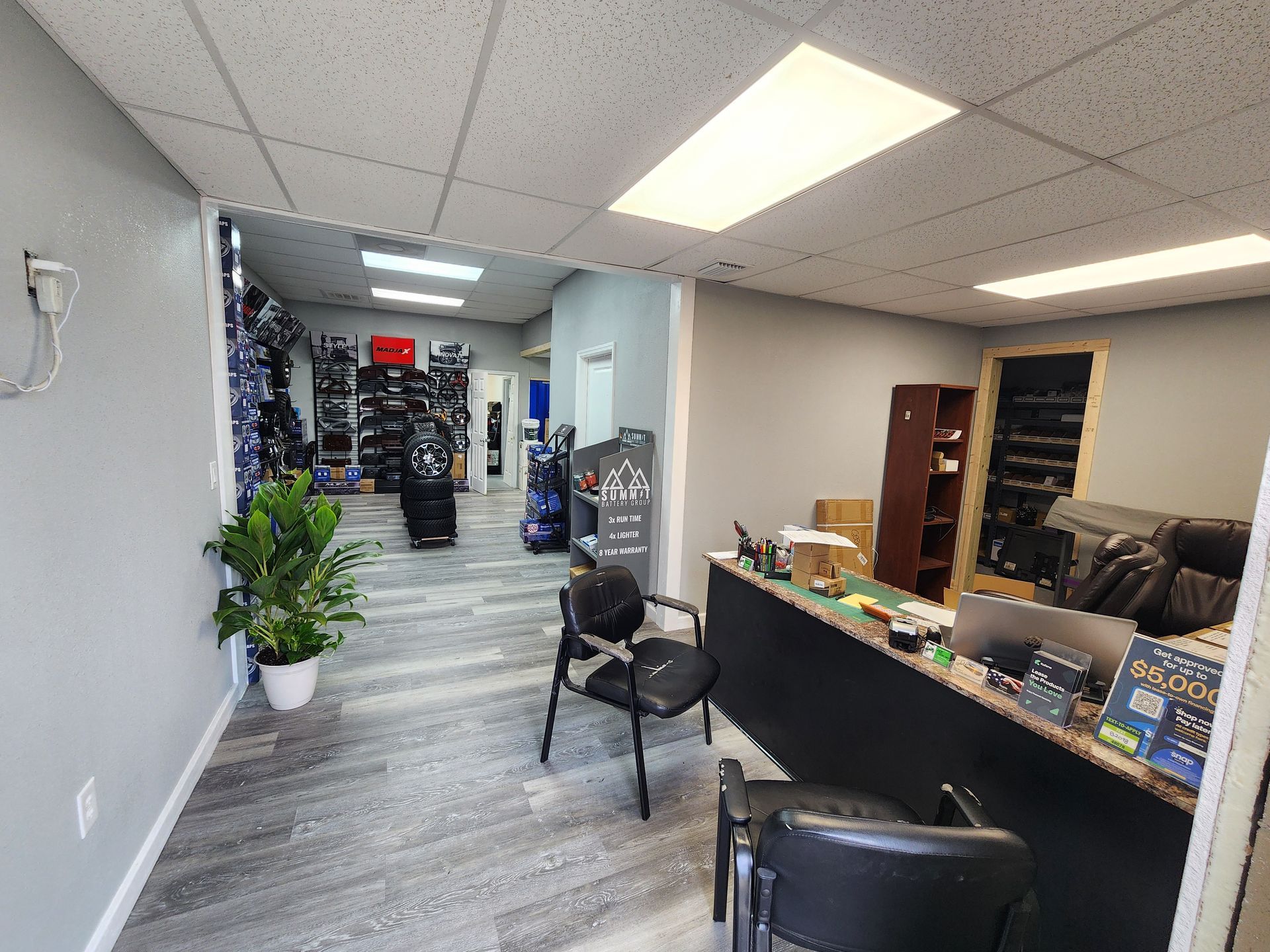 Interior shop with a reception desk, chairs, and merchandise displayed on shelves.