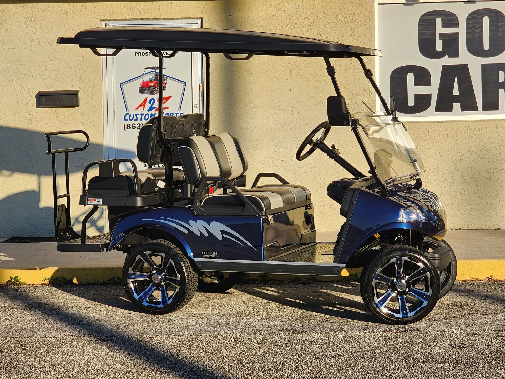 Blue and silver customized golf cart parked outside a building with 