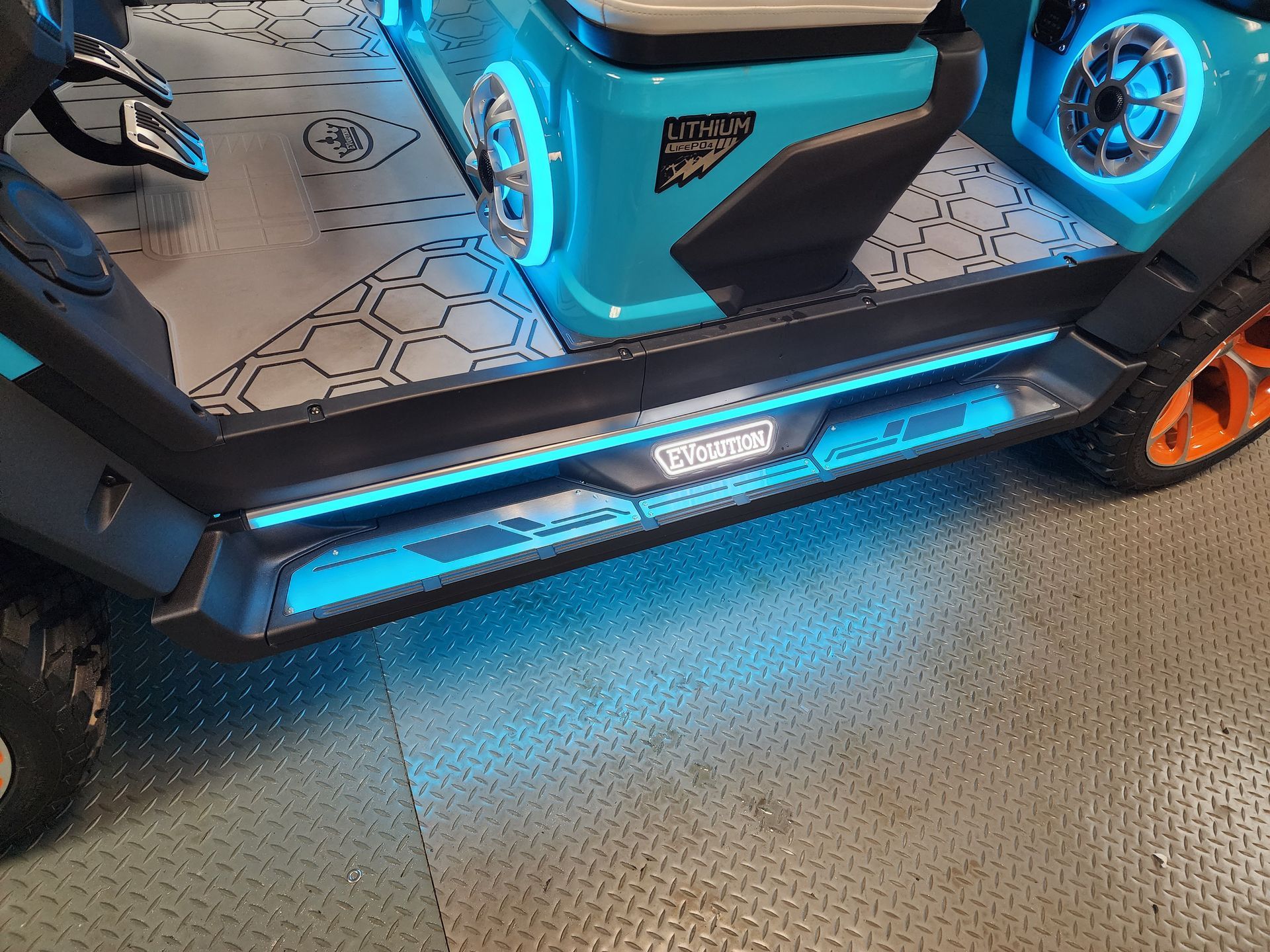 Turquoise golf cart with neon blue lights along the side panels.