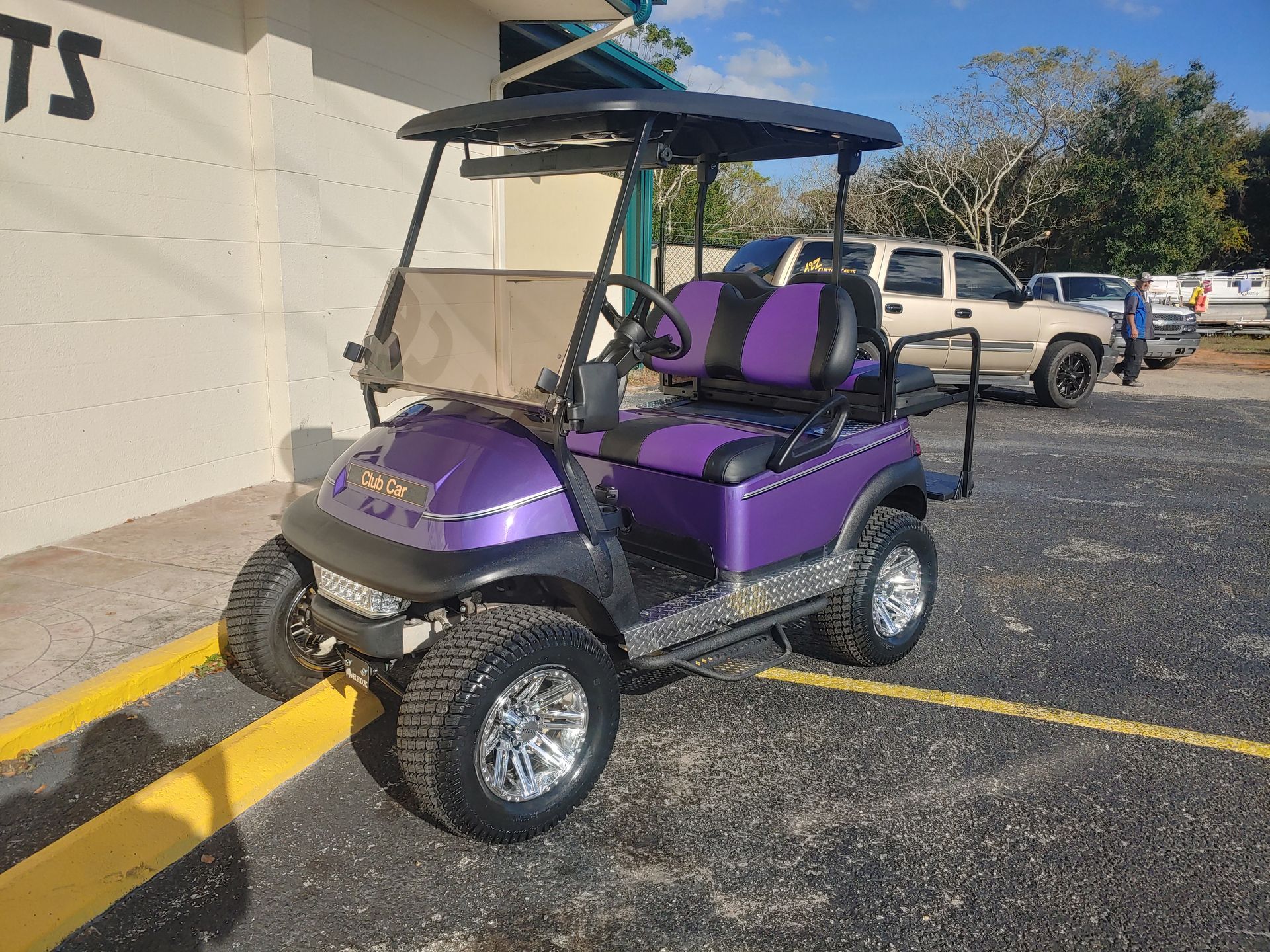 Purple golf cart with black roof parked outside.
