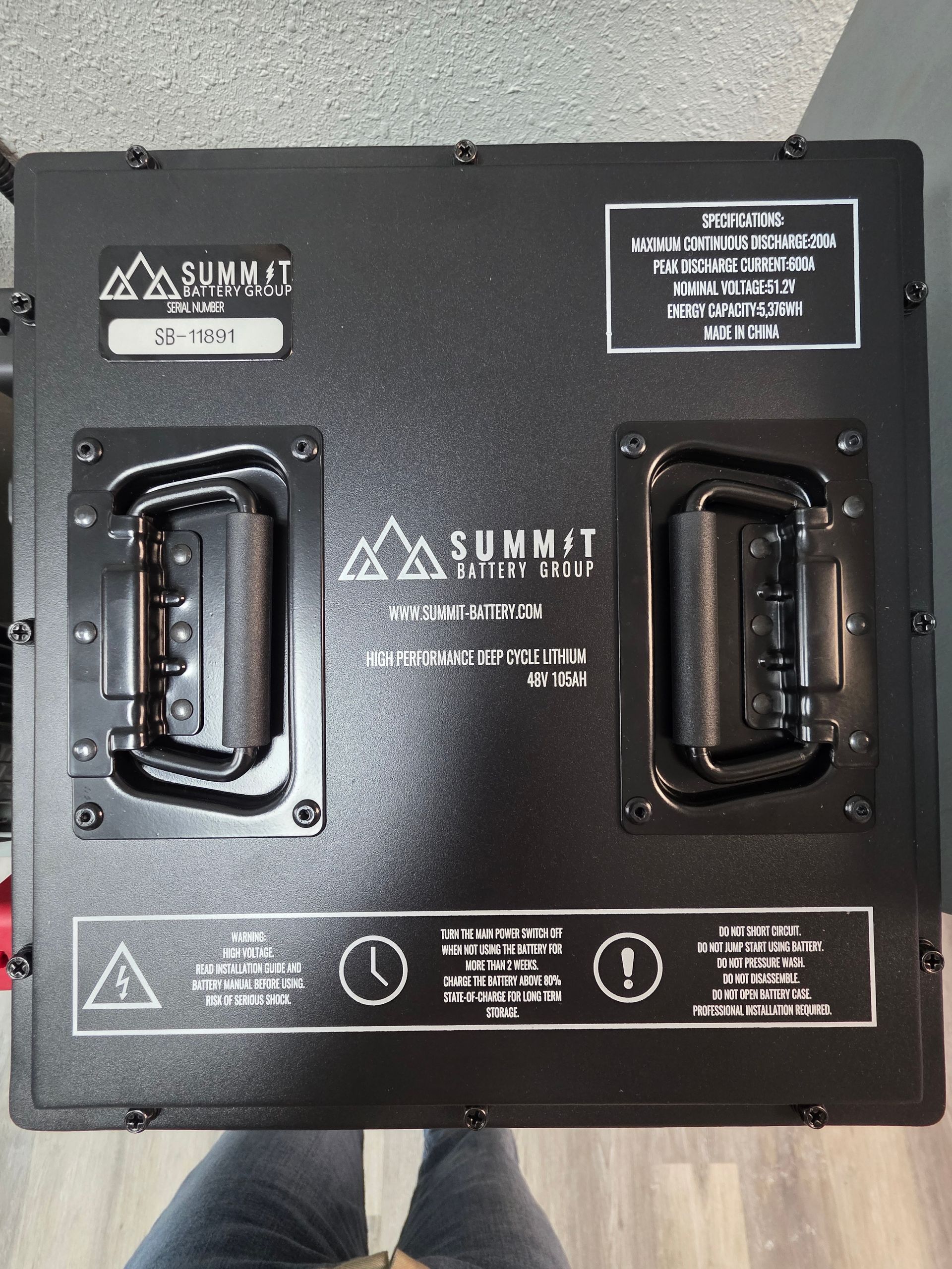 A black, rectangular Summit Battery power unit with two sturdy metal handles, safety labels, and a brand logo.
