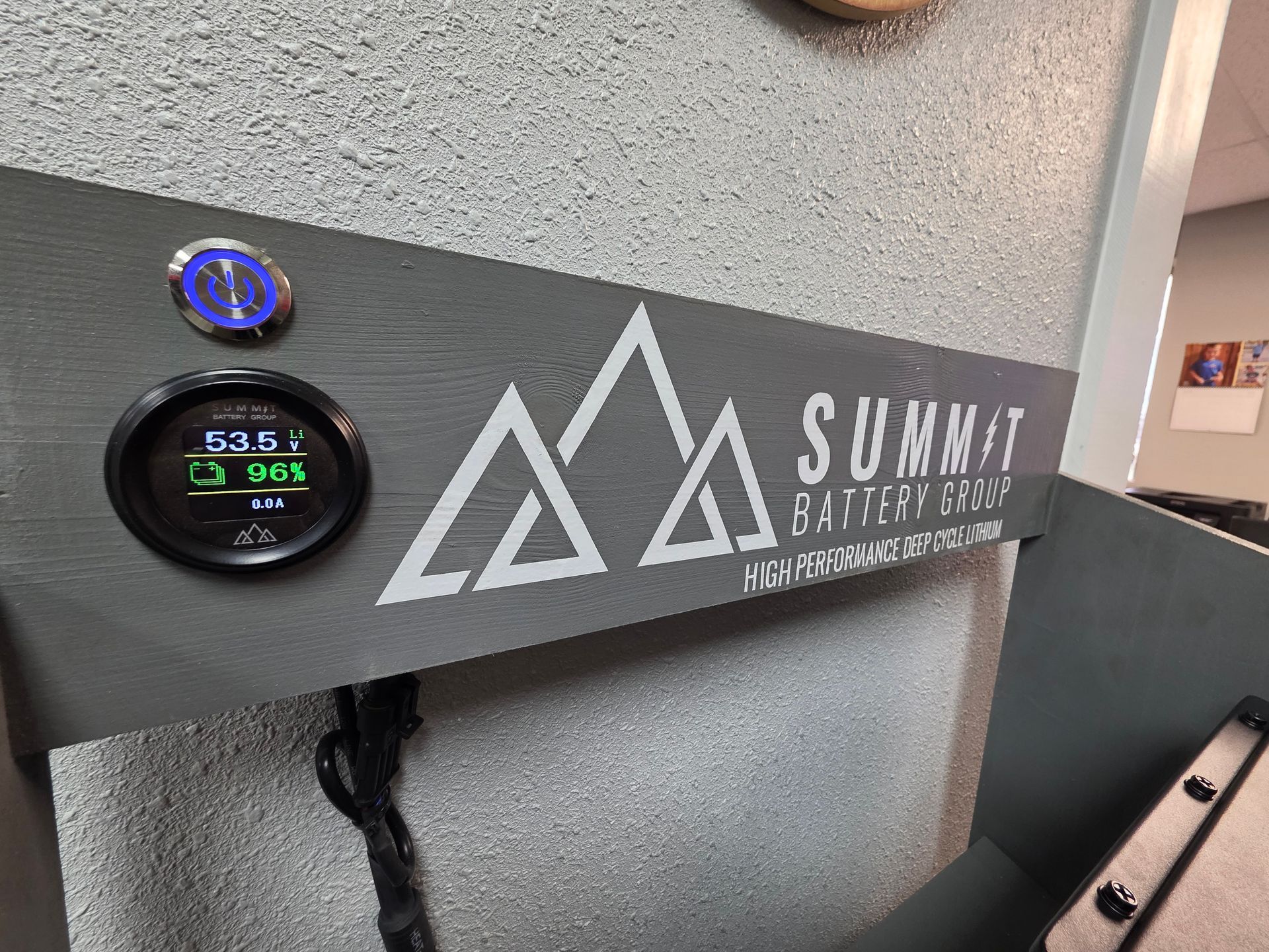 A gray mounting board for Summit Battery Systems, featuring a digital display showing 53.5V and 96% battery level.