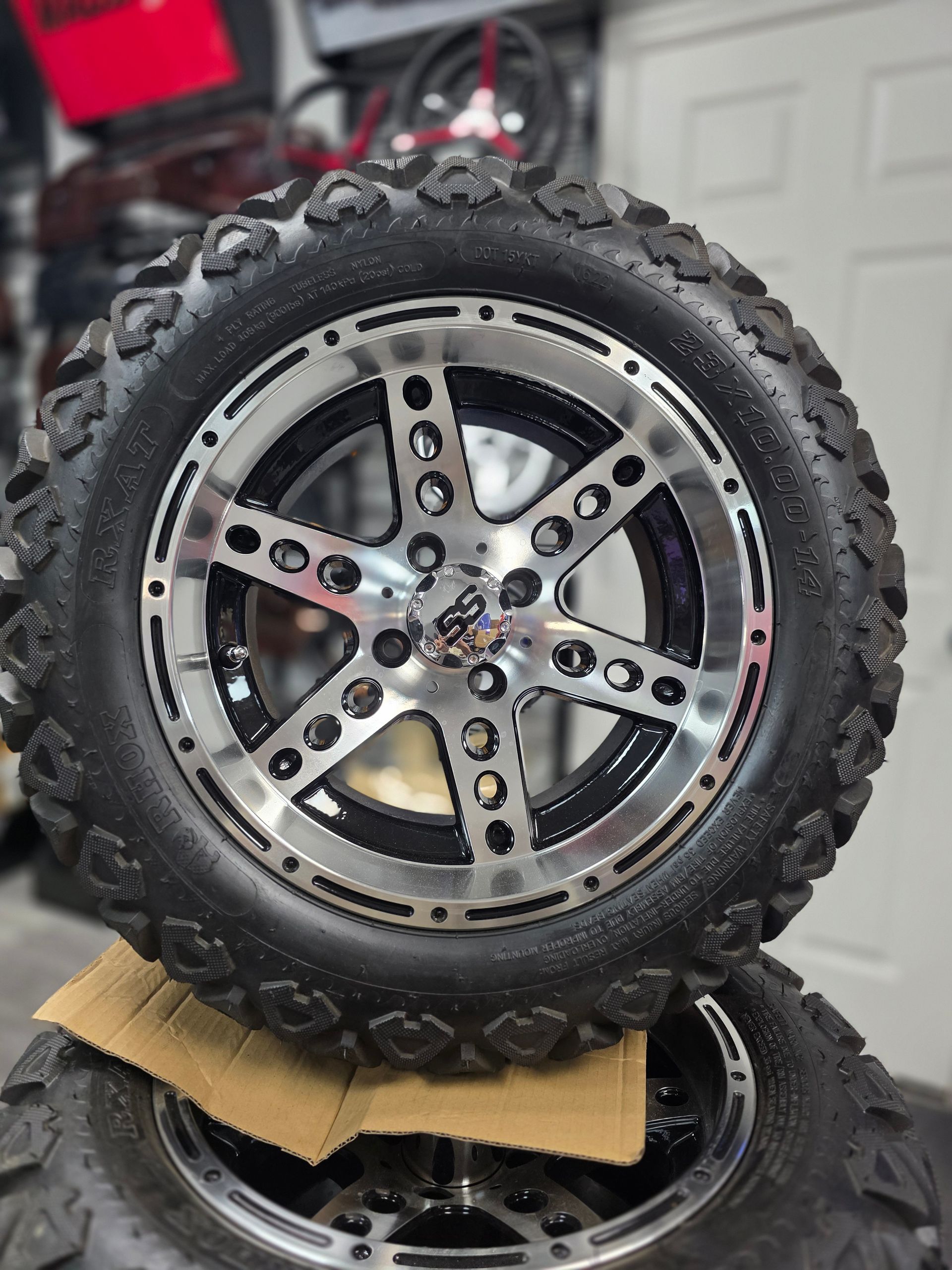 A stack of two black, off-road golf cart tires on silver and black five-spoke alloy wheels with the SS logo in the center.