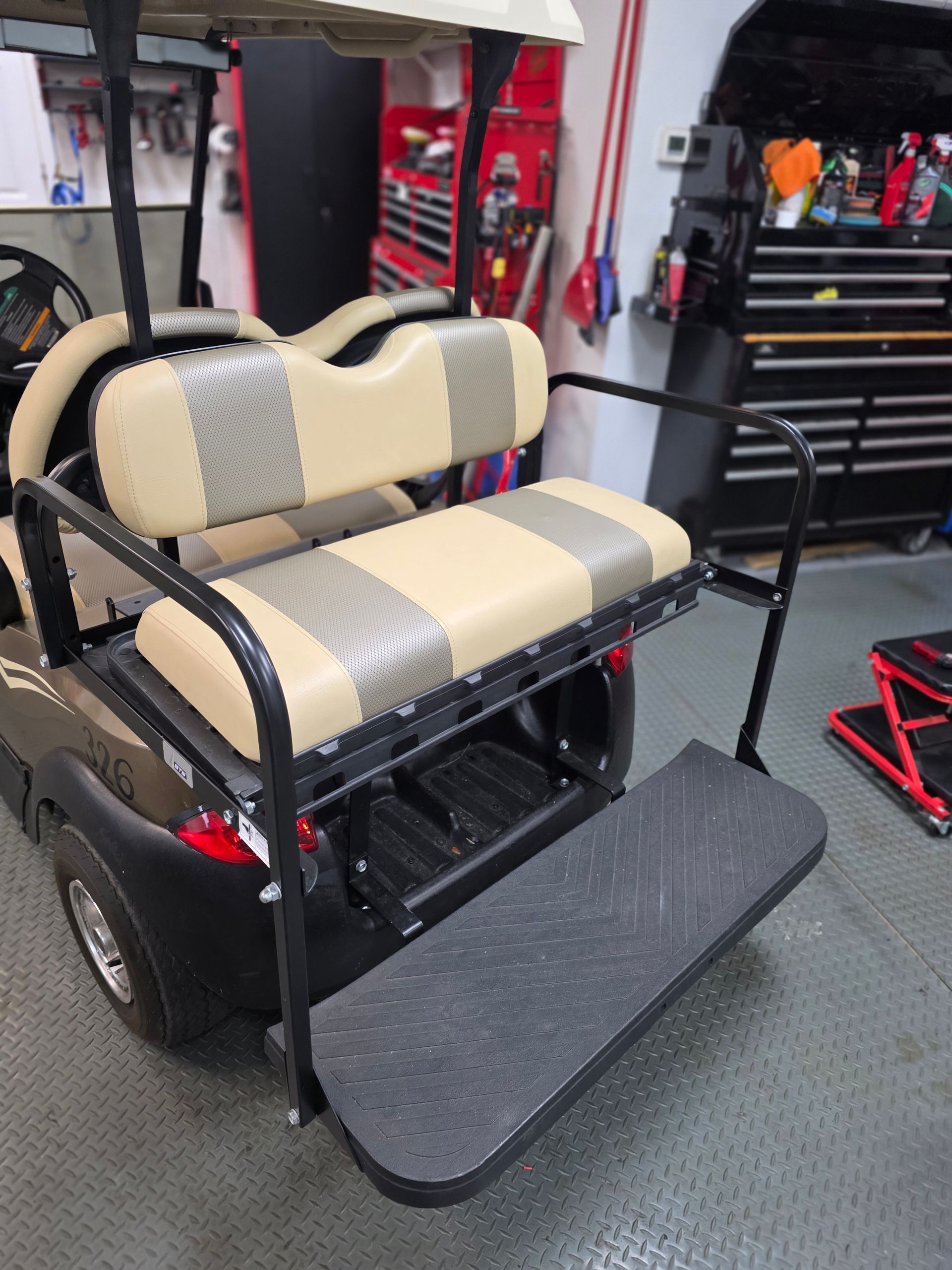 Beige and black mobility scooter with padded seats in a garage/workshop