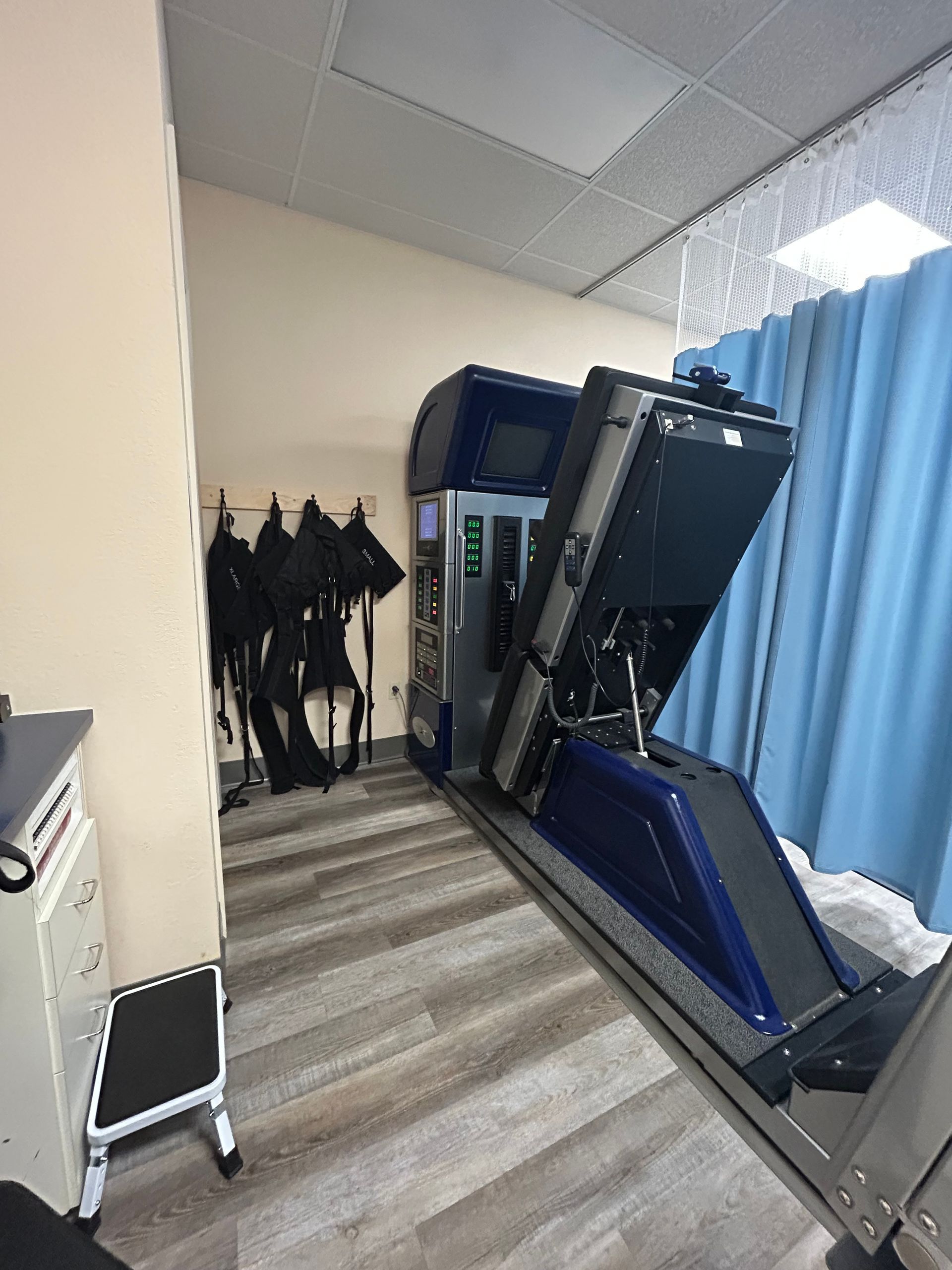 A machine is sitting in a room with a blue curtain.