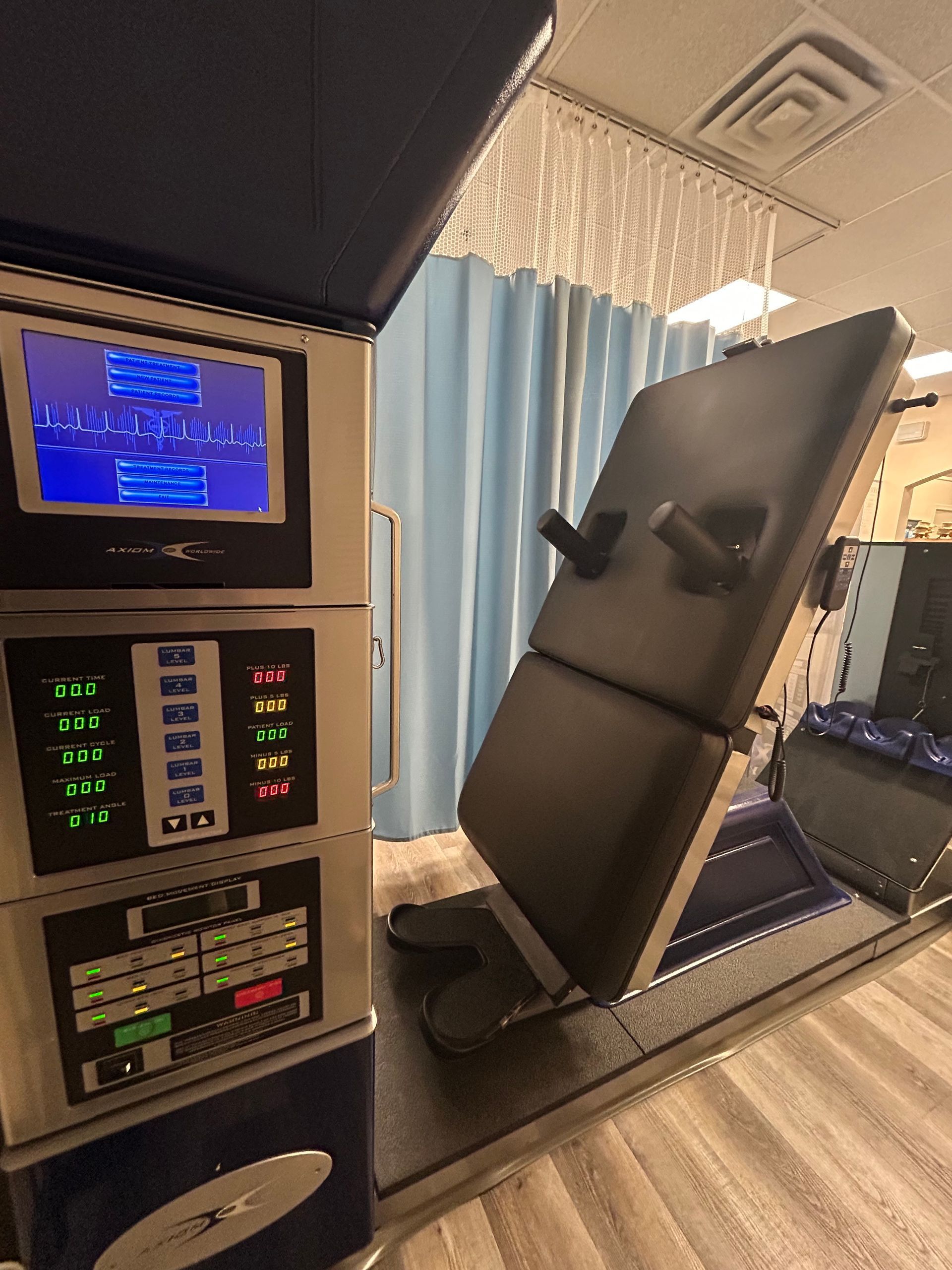 A hospital room with a bed and a monitor.