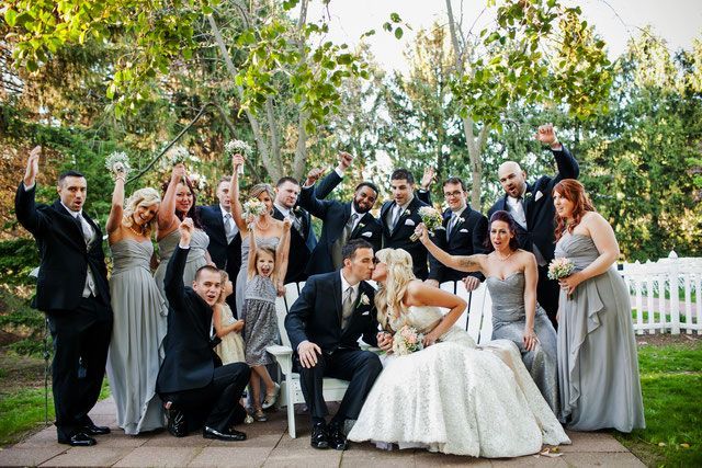 A bride and groom are posing for a picture with their wedding party.