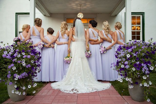 A bride and her bridesmaids are posing for a picture in front of a building.