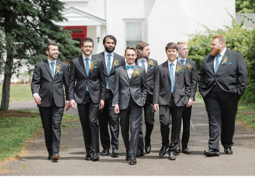 A group of men in suits and ties are walking down a street.