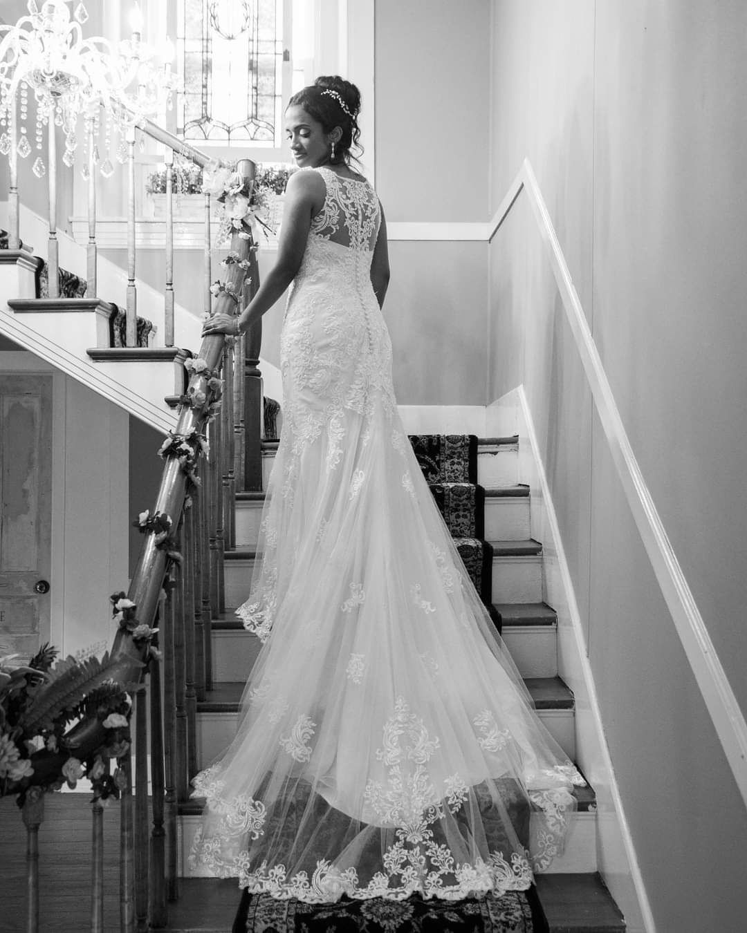 A bride in a wedding dress is standing on a set of stairs.