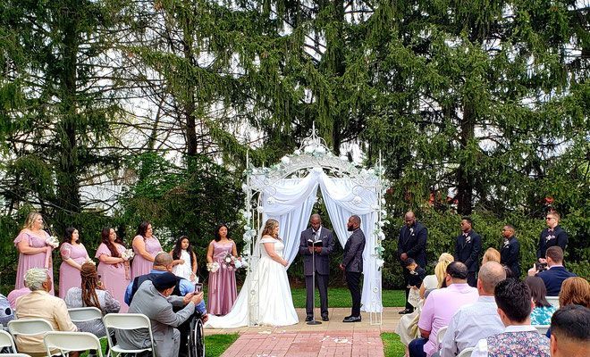 A bride and groom are getting married in front of a crowd of people.