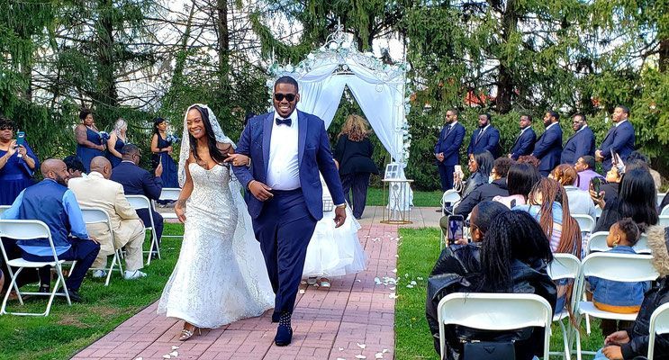 A bride and groom are walking down the aisle at their wedding.