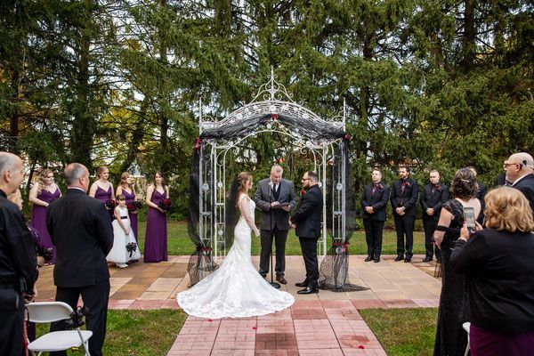 A bride and groom are getting married in front of a crowd of people.