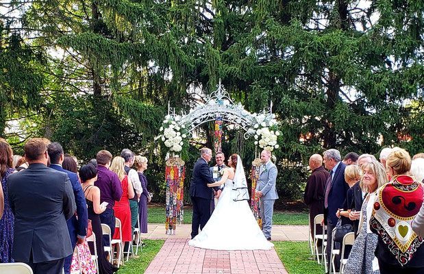 A bride and groom are walking down the aisle at their outdoor wedding ceremony.