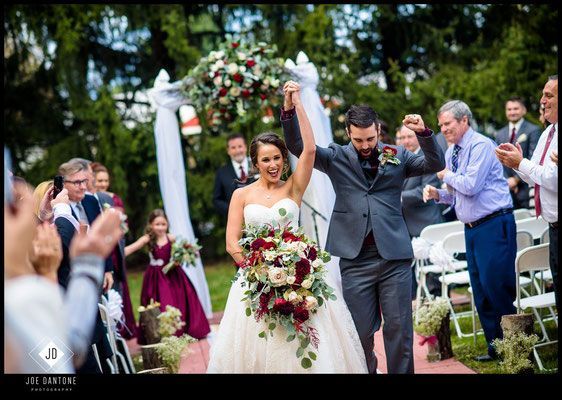 A bride and groom are walking down the aisle at their wedding.
