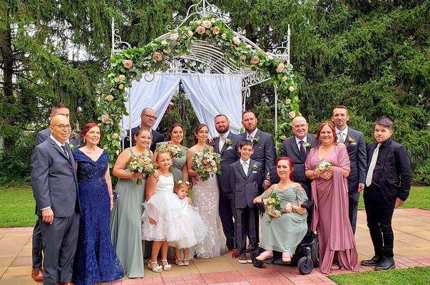 A group of people are posing for a picture at a wedding.