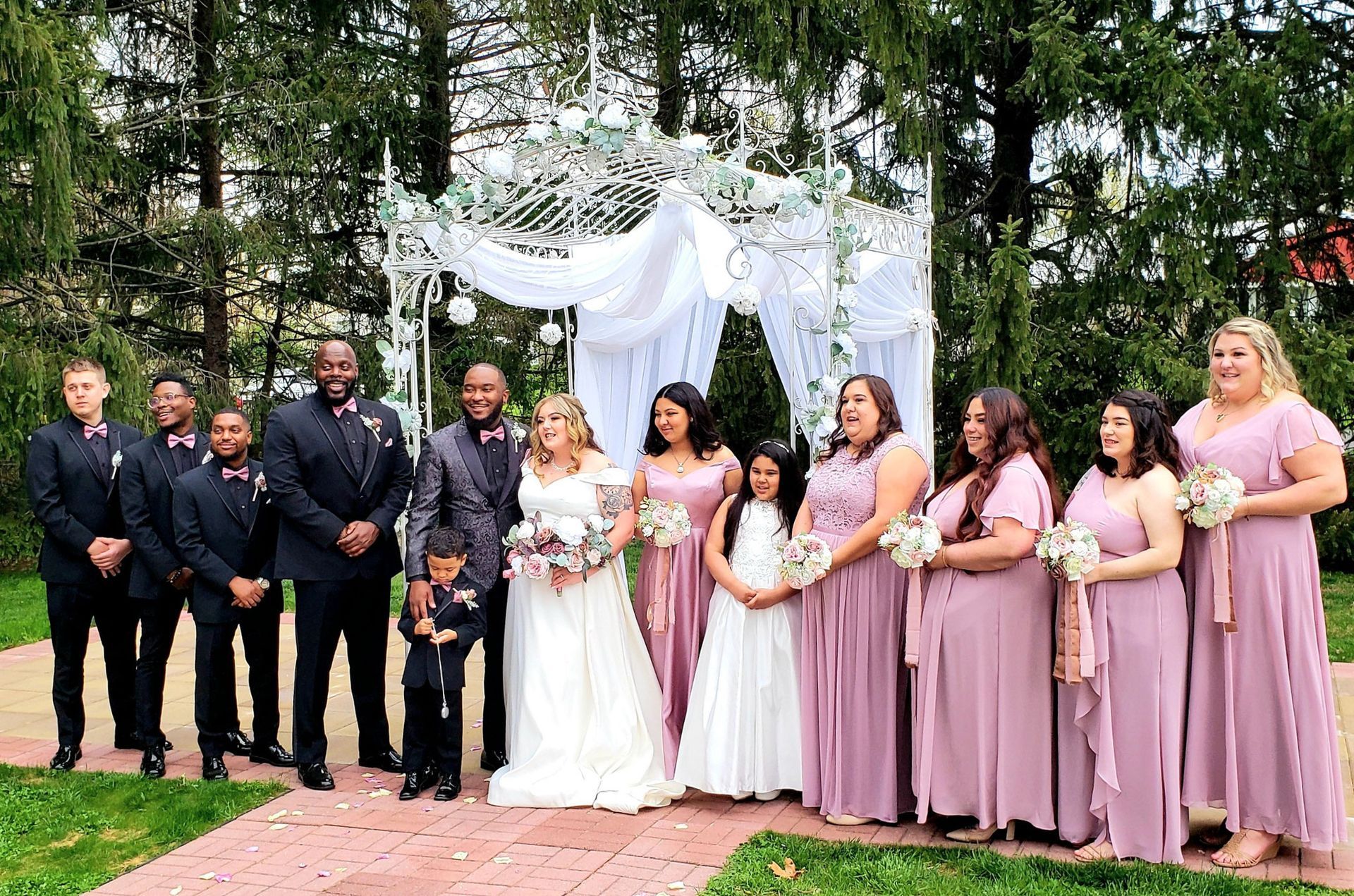 A bride and groom are posing for a picture with their wedding party.
