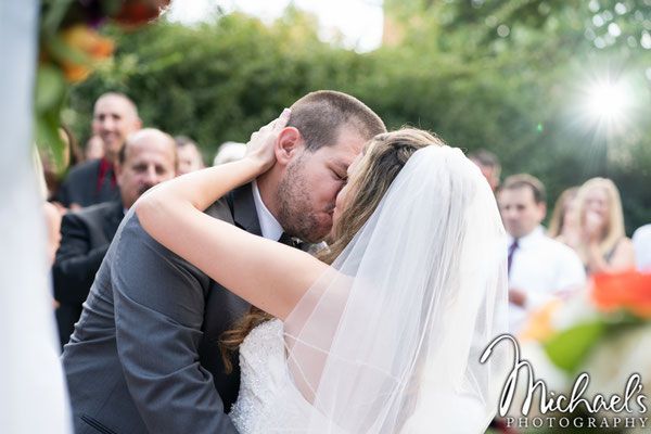 A bride and groom kissing during their wedding ceremony