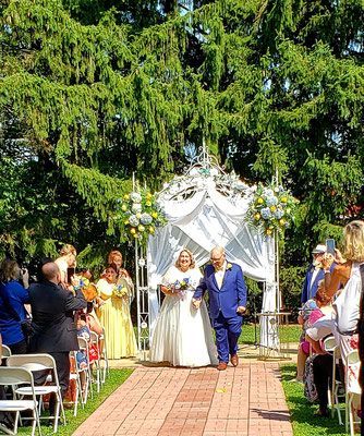 A bride and groom are walking down the aisle at their wedding.