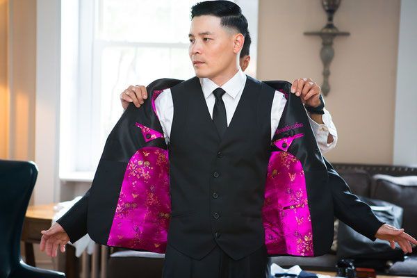 A man in a suit and tie is getting ready for his wedding.