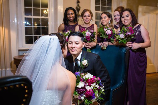 A bride and groom are posing for a picture with their bridesmaids.