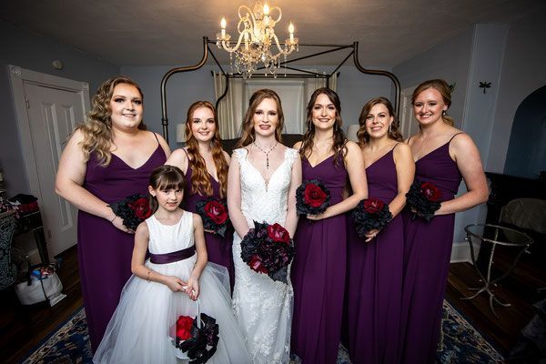 A bride and her bridesmaids are posing for a picture in a room.