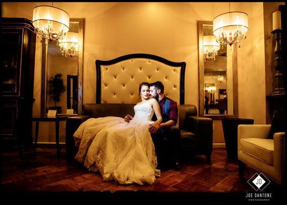 A bride and groom are sitting on a couch in a room.