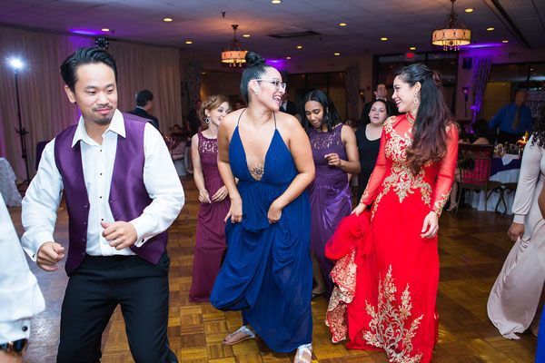 A group of people are dancing together at a wedding reception.