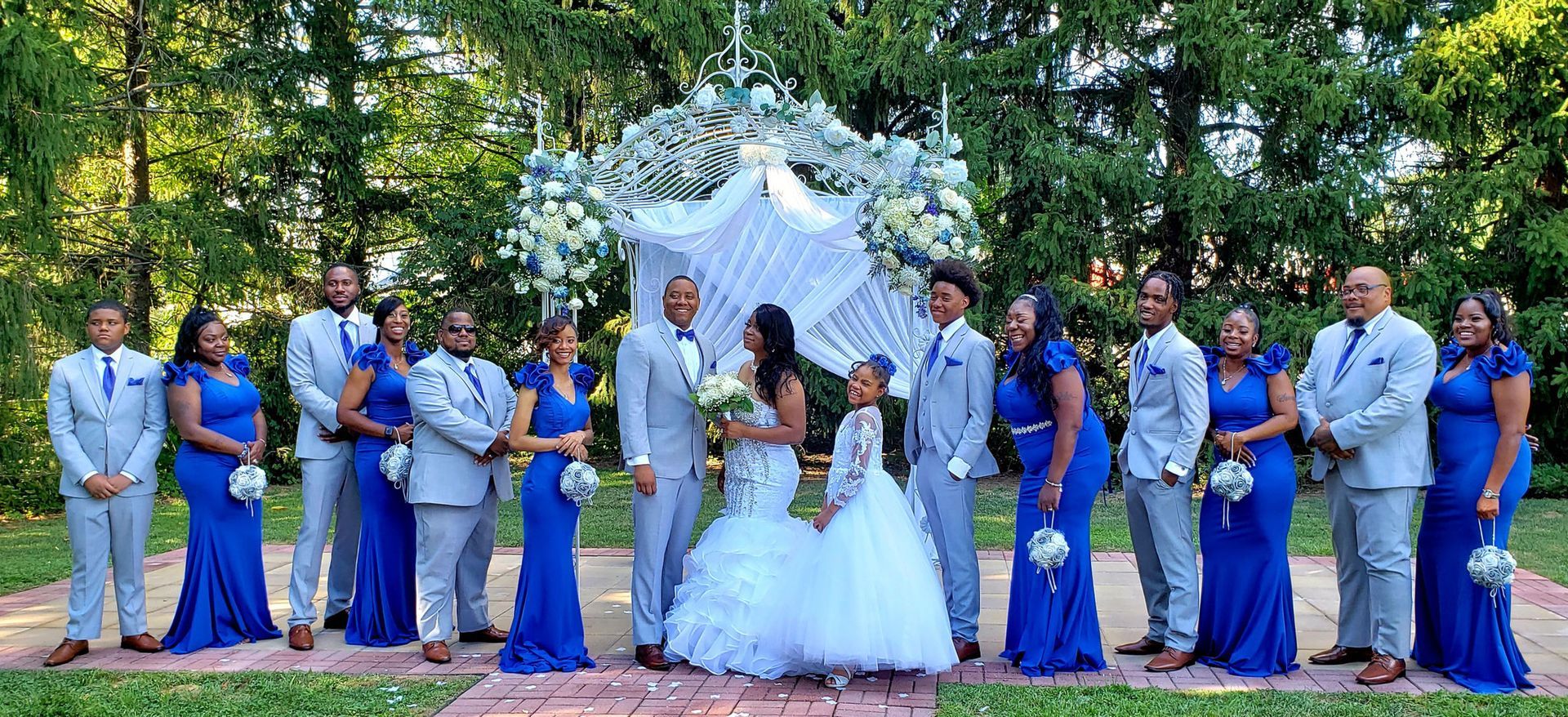 A bride and groom are posing for a picture with their wedding party.