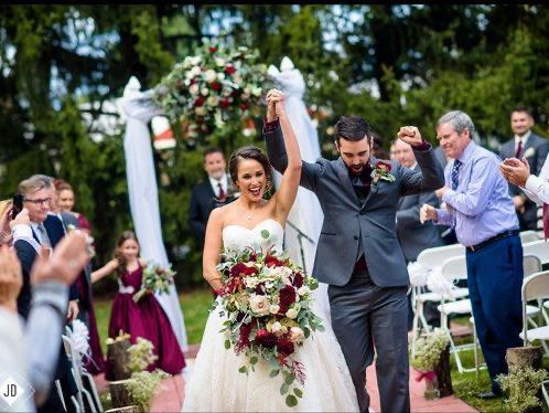 A bride and groom are walking down the aisle at their wedding.