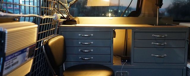 A desk with drawers and a chair in a van