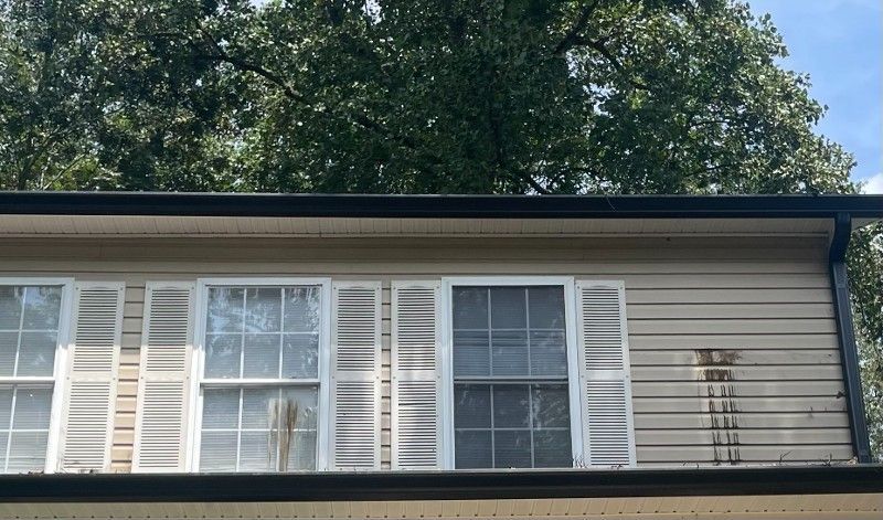 A house with a lot of windows and shutters on it.