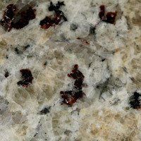 A close up of a granite counter top with red spots.