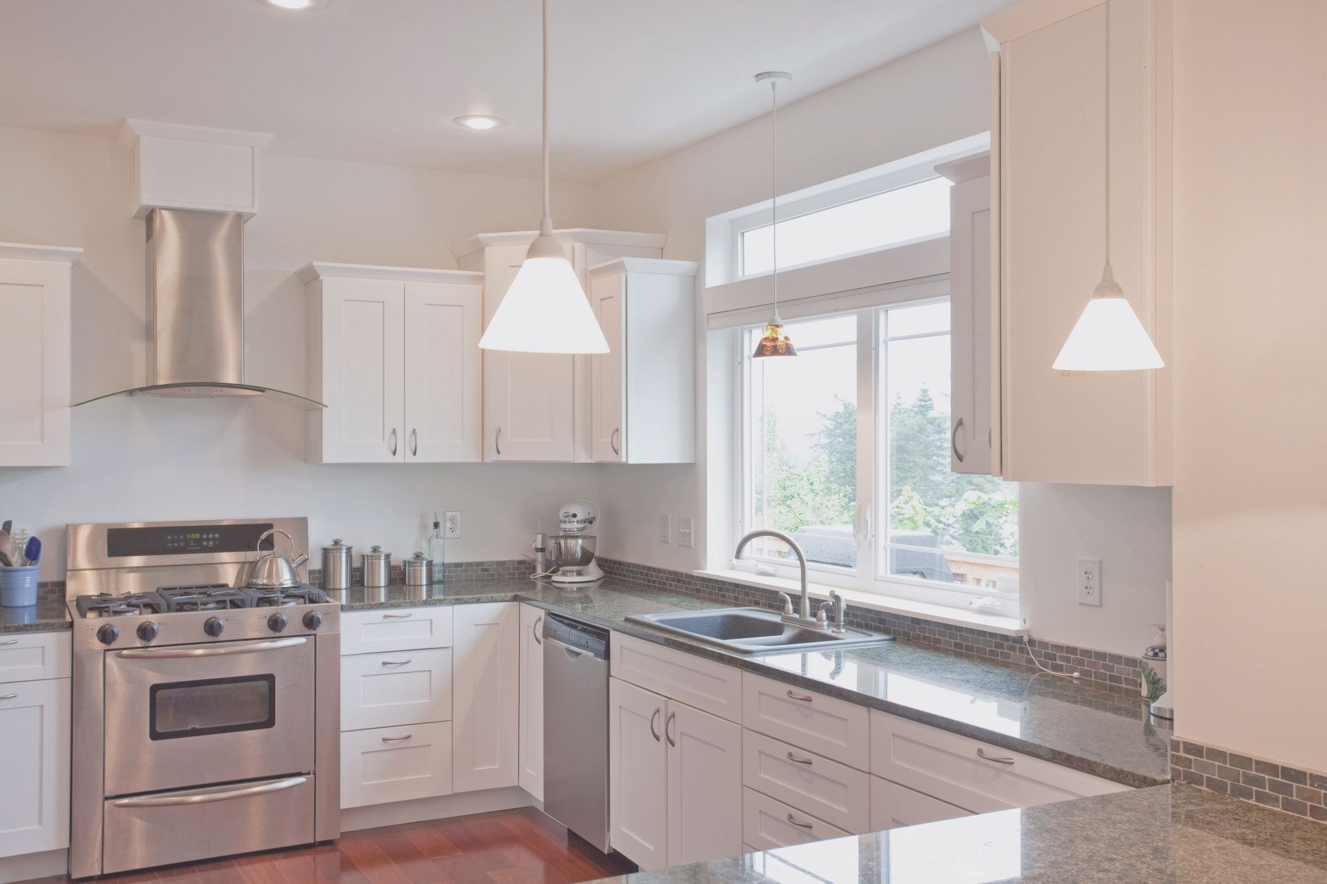 A kitchen with white cabinets and stainless steel appliances