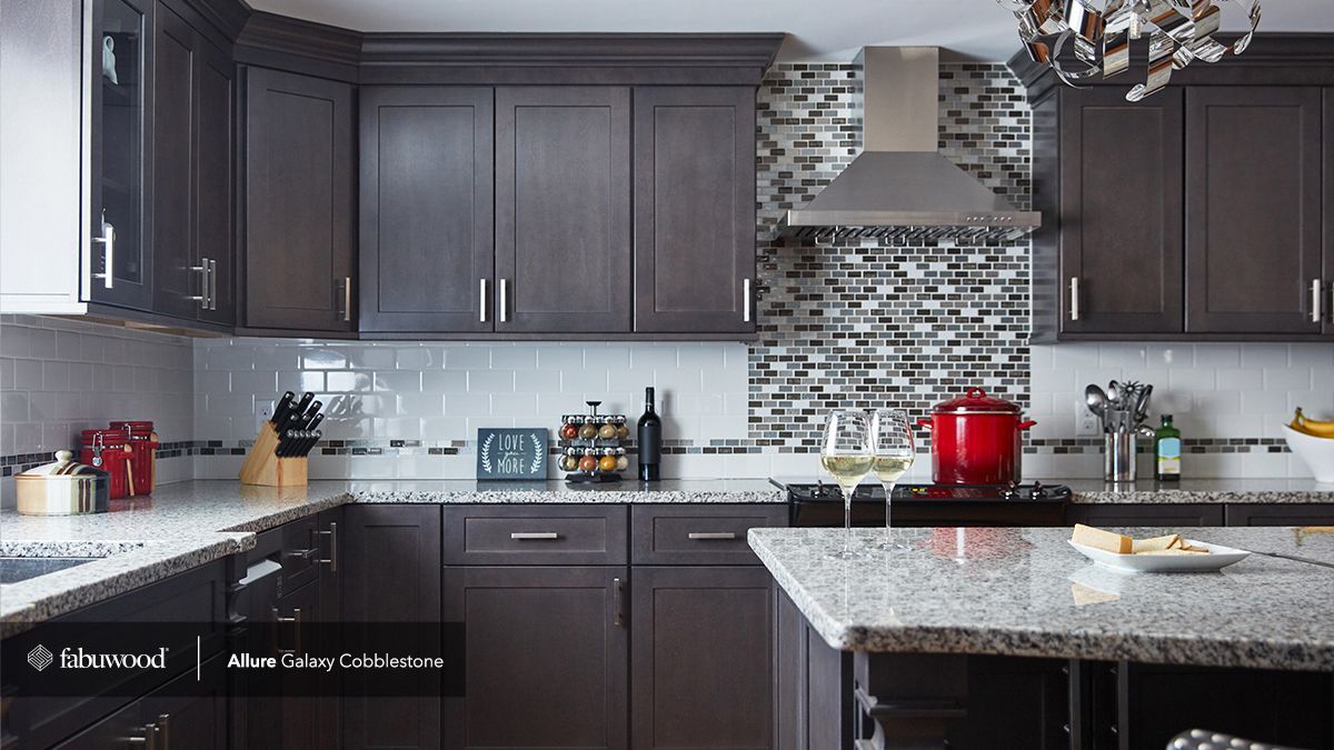 A kitchen with gray cabinets and granite counter tops