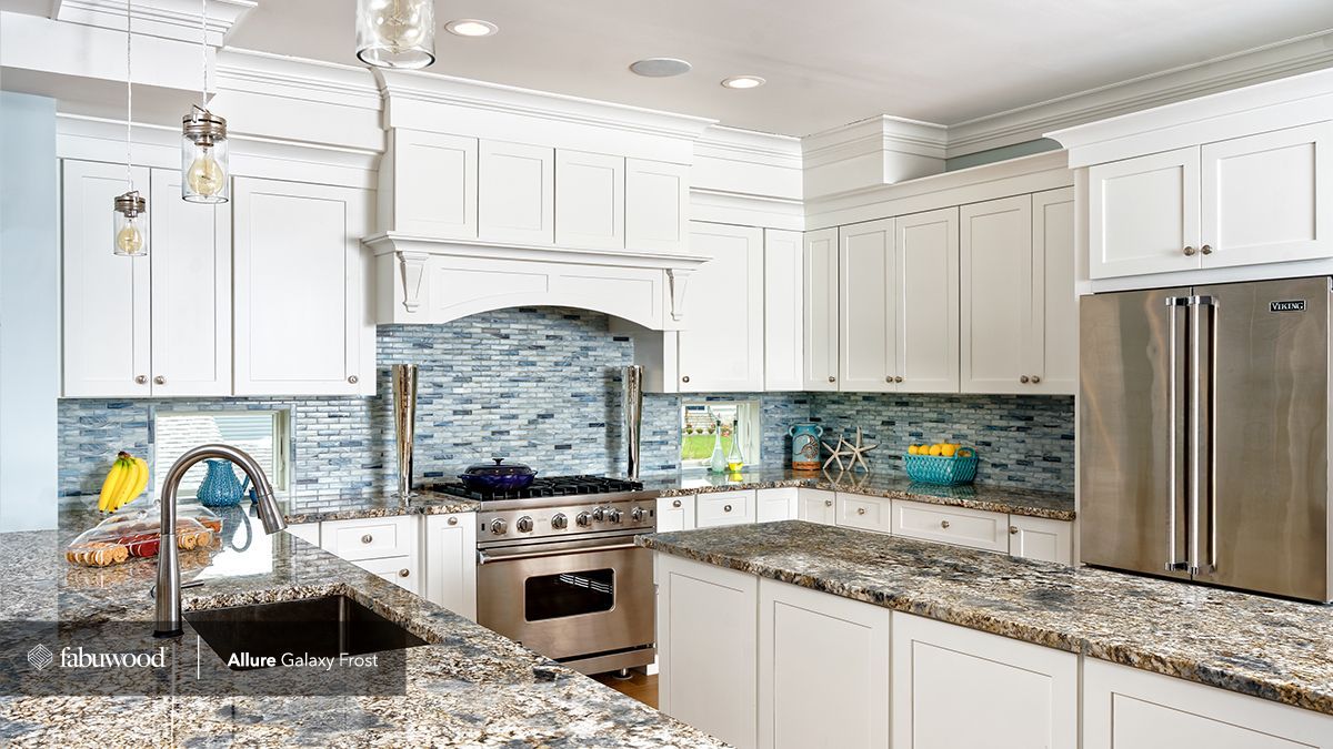 A kitchen with white cabinets, granite countertops, stainless steel appliances, and a sink.