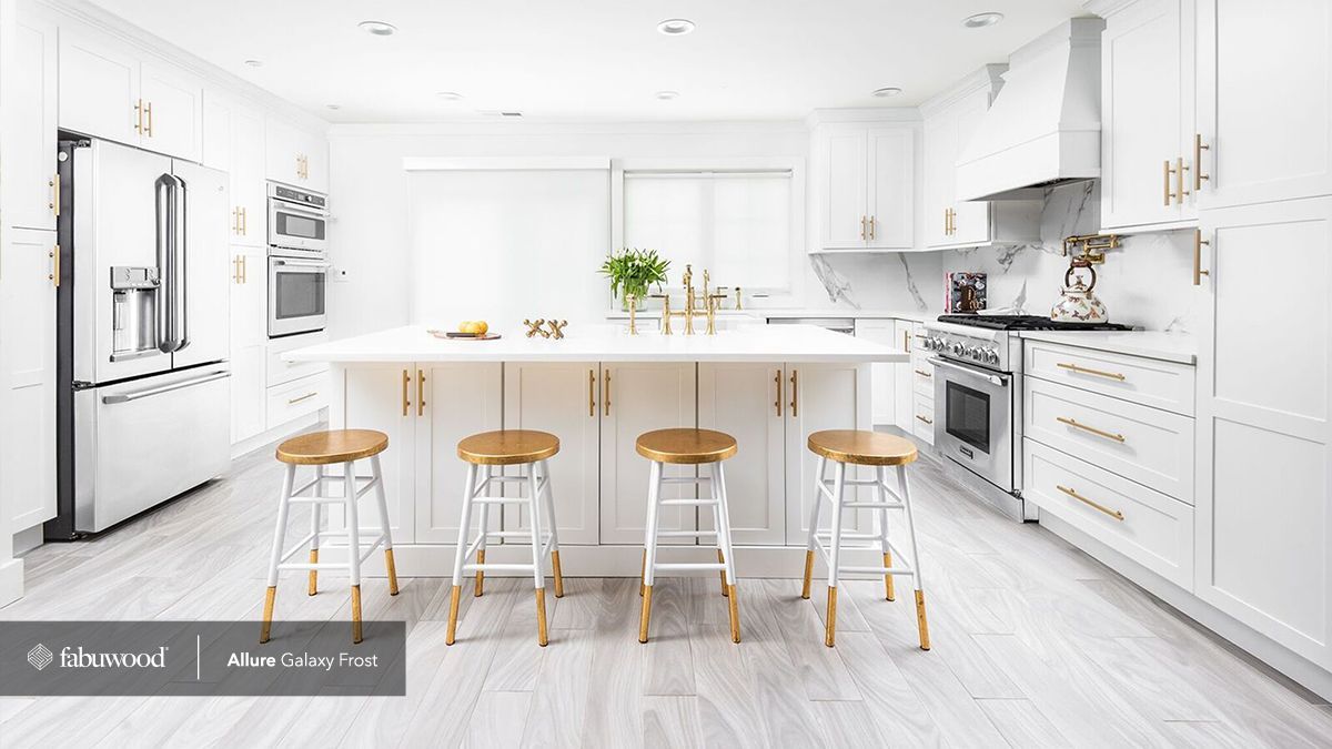 A kitchen with white cabinets, stainless steel appliances, and wooden stools.