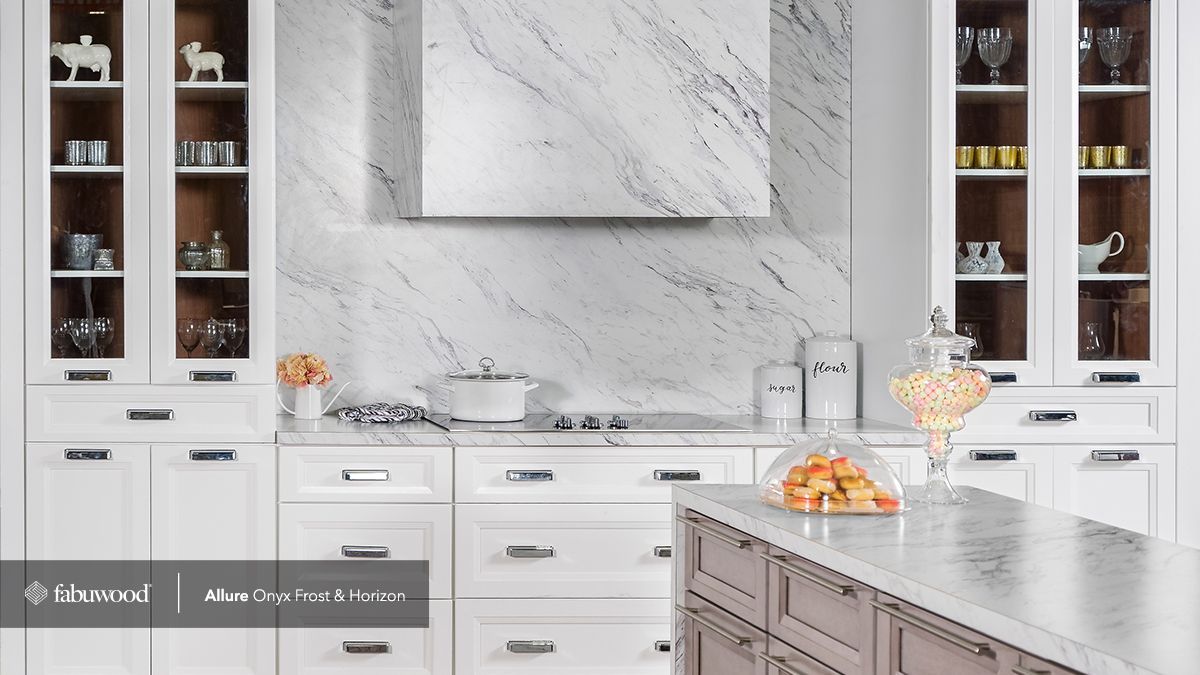 A kitchen with white cabinets and a marble countertop.