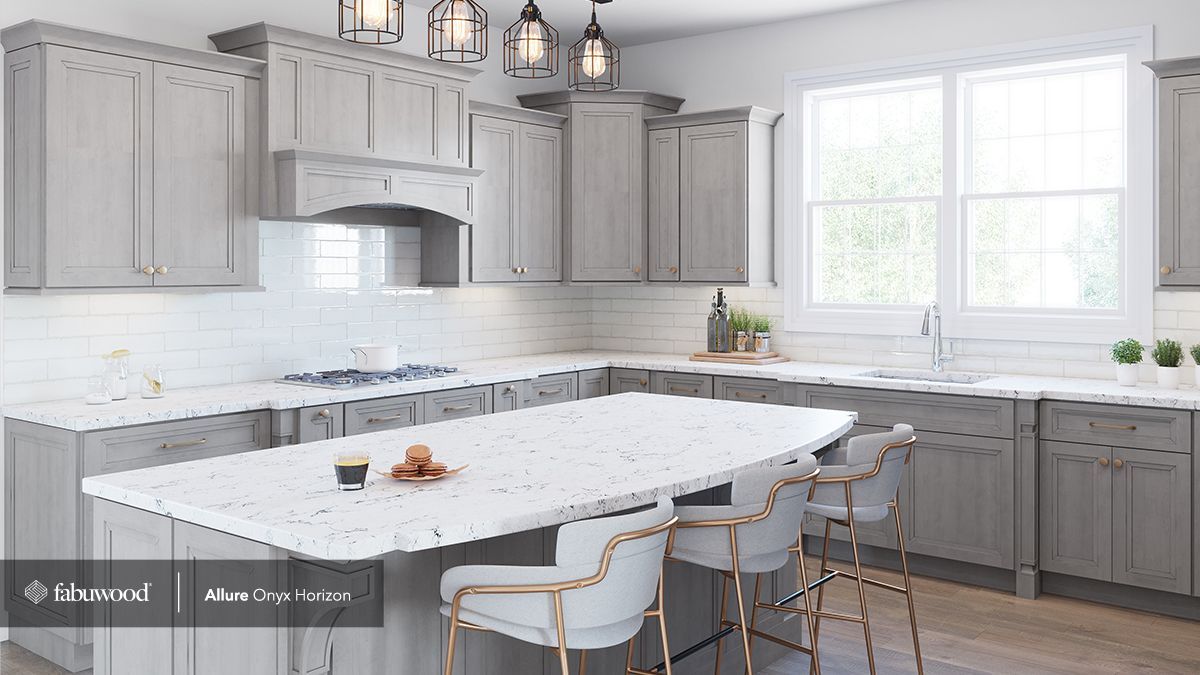 A kitchen with gray cabinets, white countertops, and a large island.