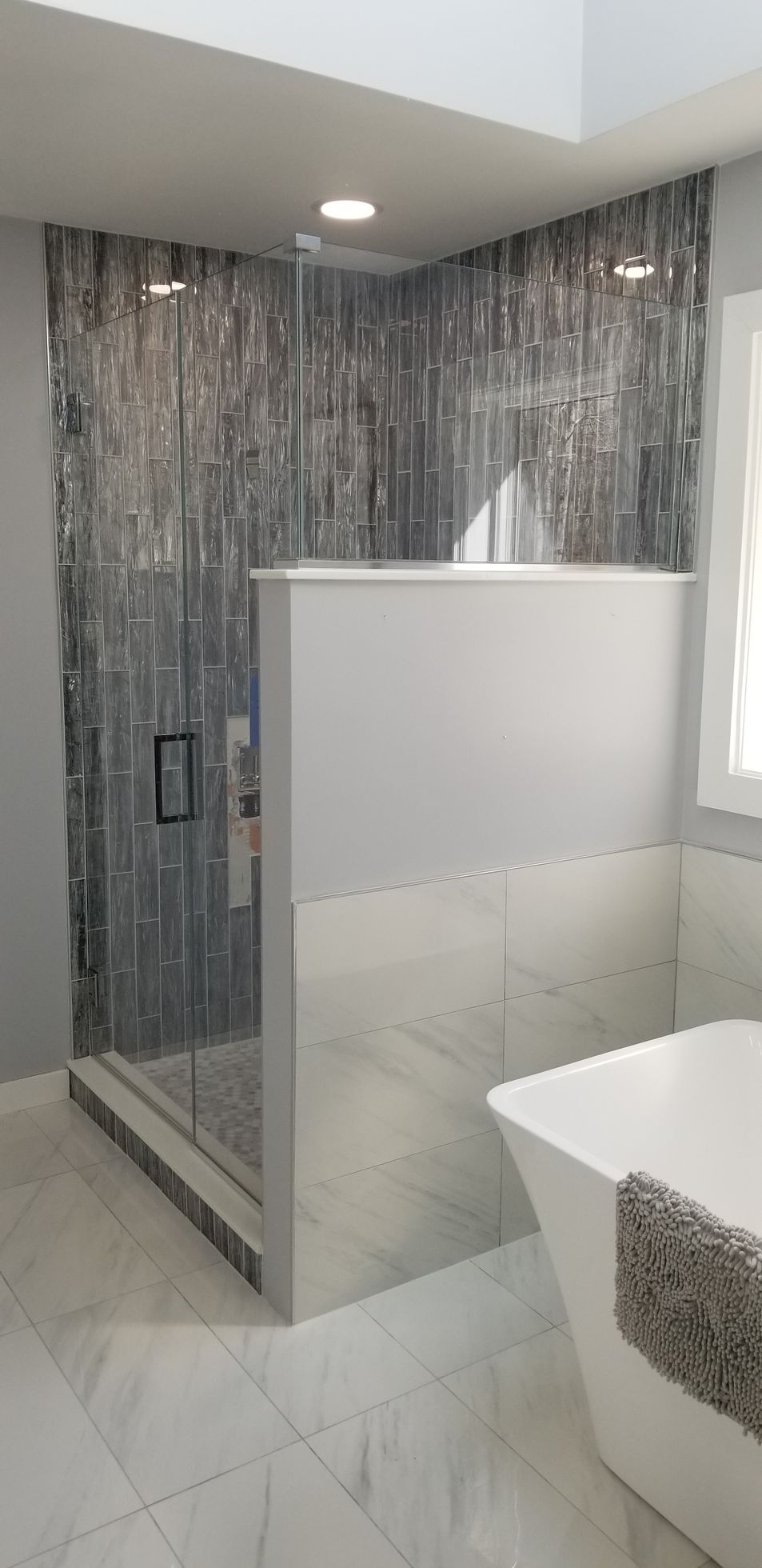 A bathroom with a walk in shower and a bathtub.