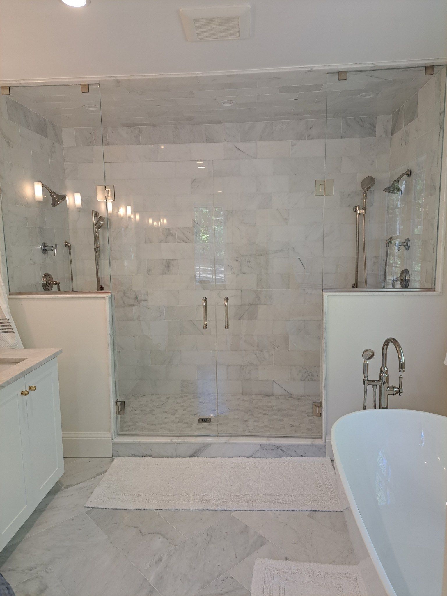 A bathroom with a walk in shower and a bathtub.