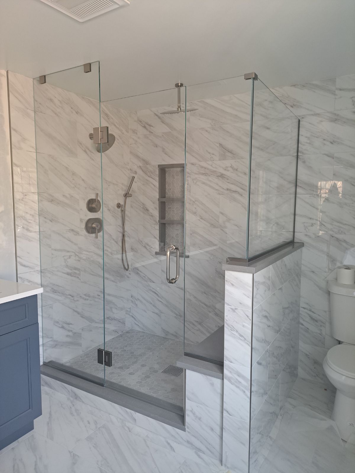 A bathroom with a walk in shower and a toilet.