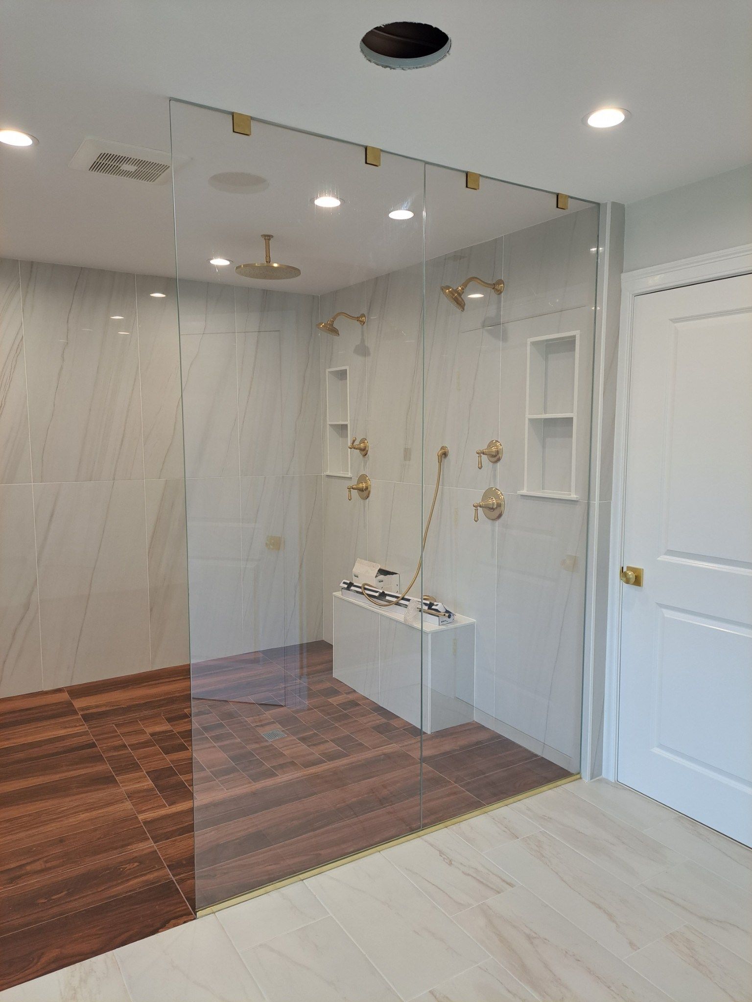 A bathroom with a walk in shower and a bench.